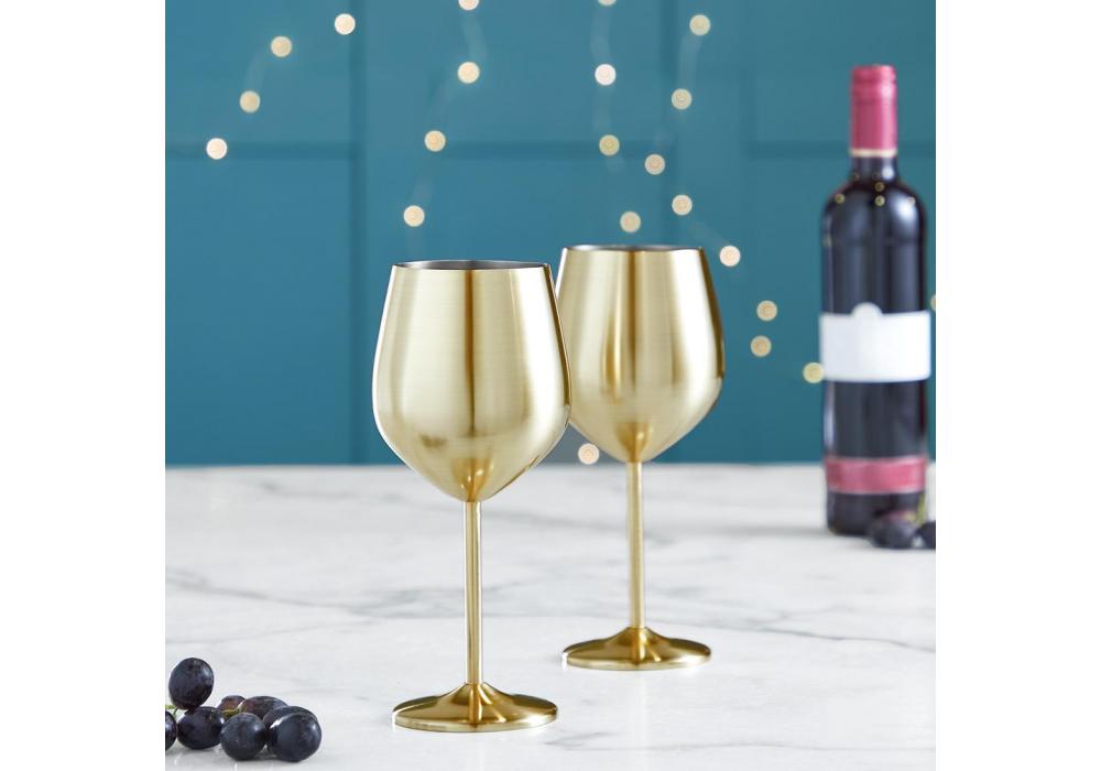 Two gold wine glasses and a bottle of red wine.
