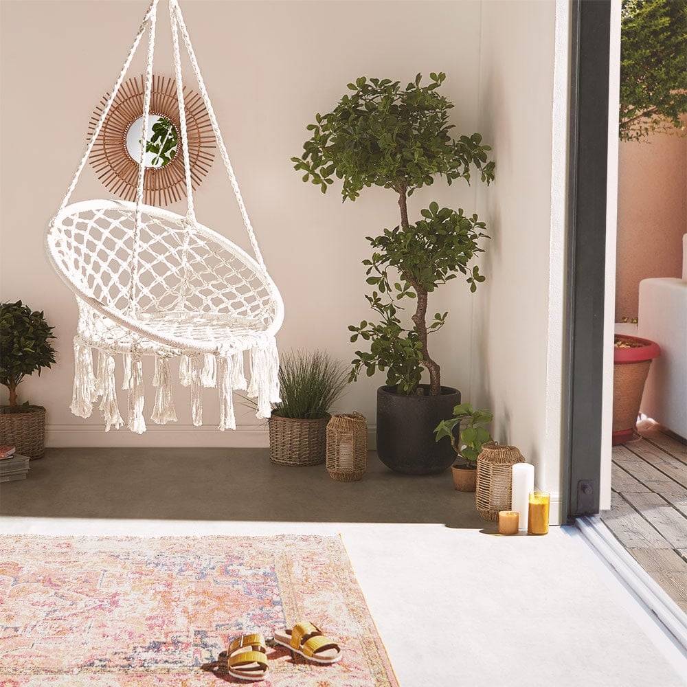 White boho-style hanging chair in a bohomeian-style living room
