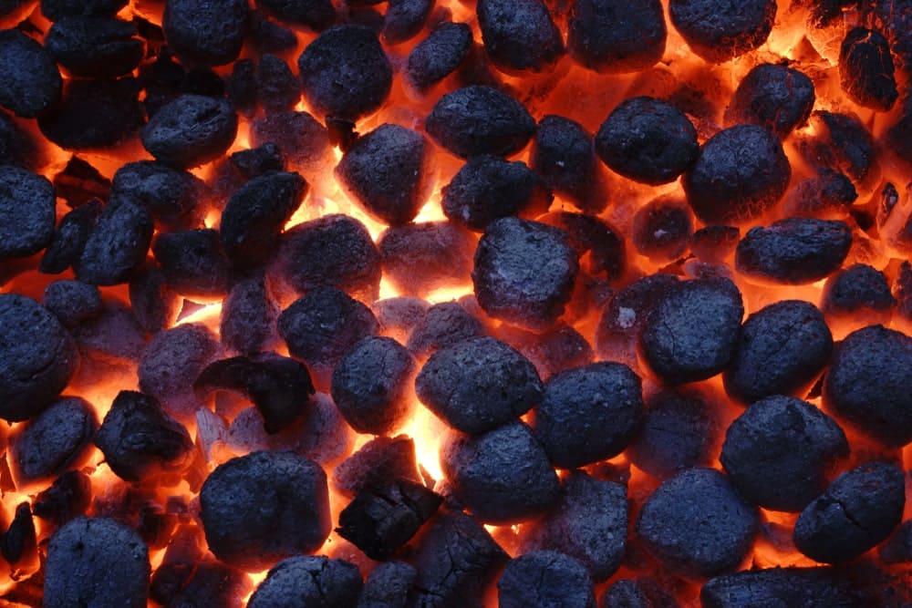 Charcoal briquettes smouldering on a barbecue
