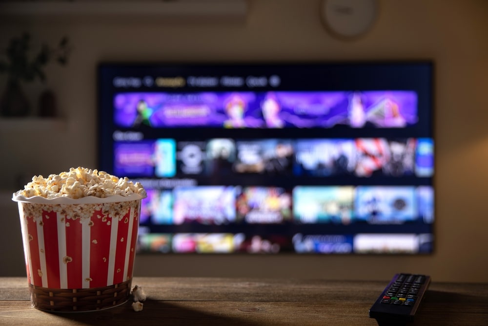 Closeup of popcorn in front of a large smart TV
