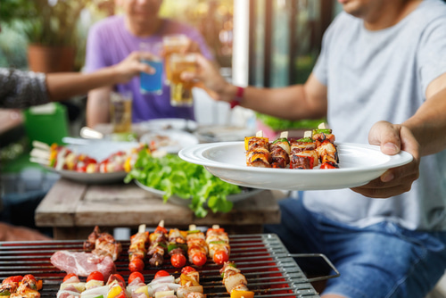 Man offering you a plate at a BBQ