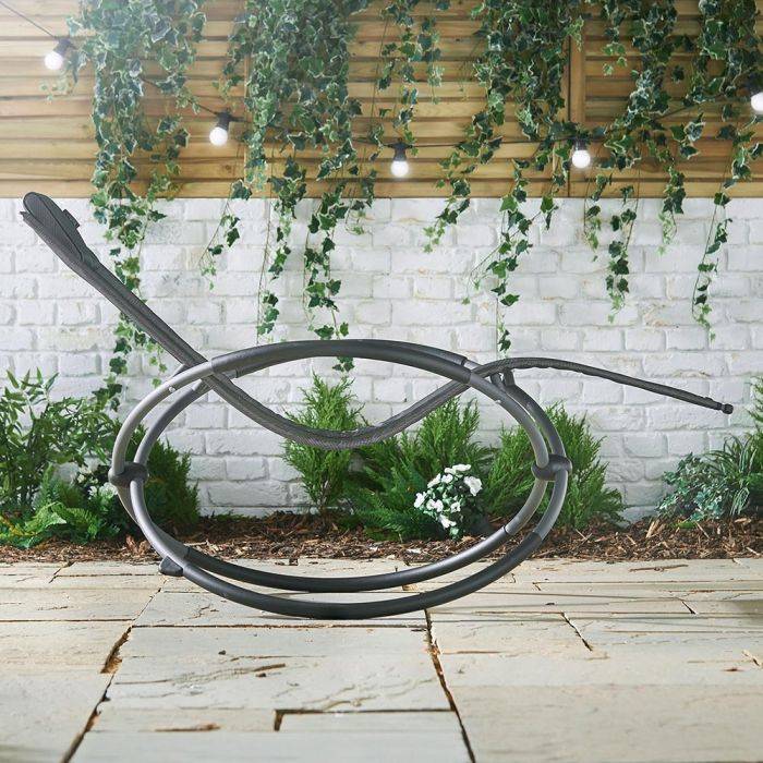 Sideview of a grey garden recliner on a stone patio
