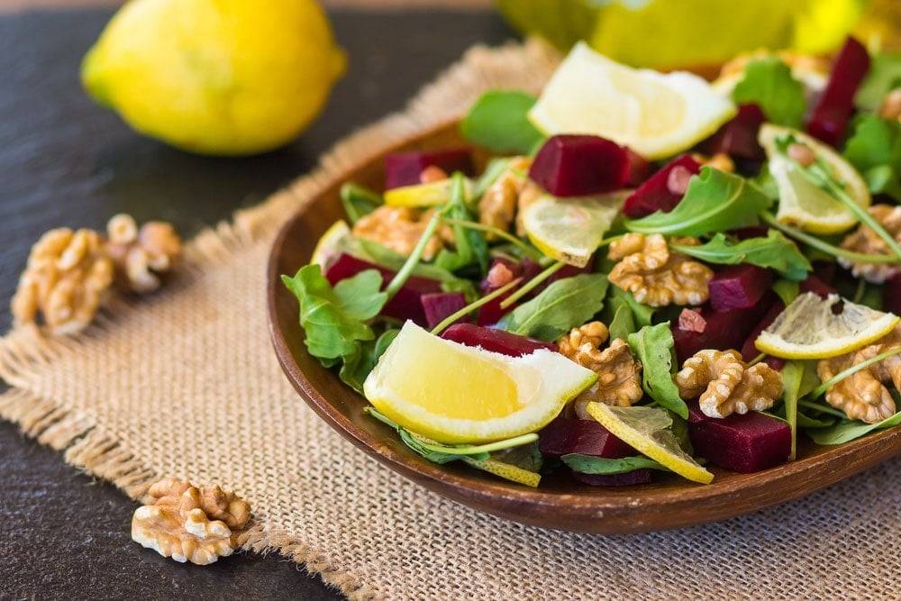 A vegetarian walnut salad in a rustic wooden dish