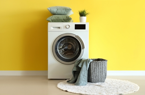 Washing machine in a bright yellow utility room