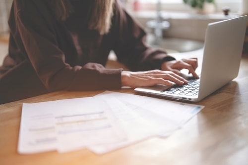 Woman calculating bills on laptop