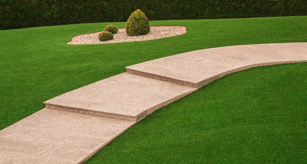 Artificial grass with a curved paved path through the middle