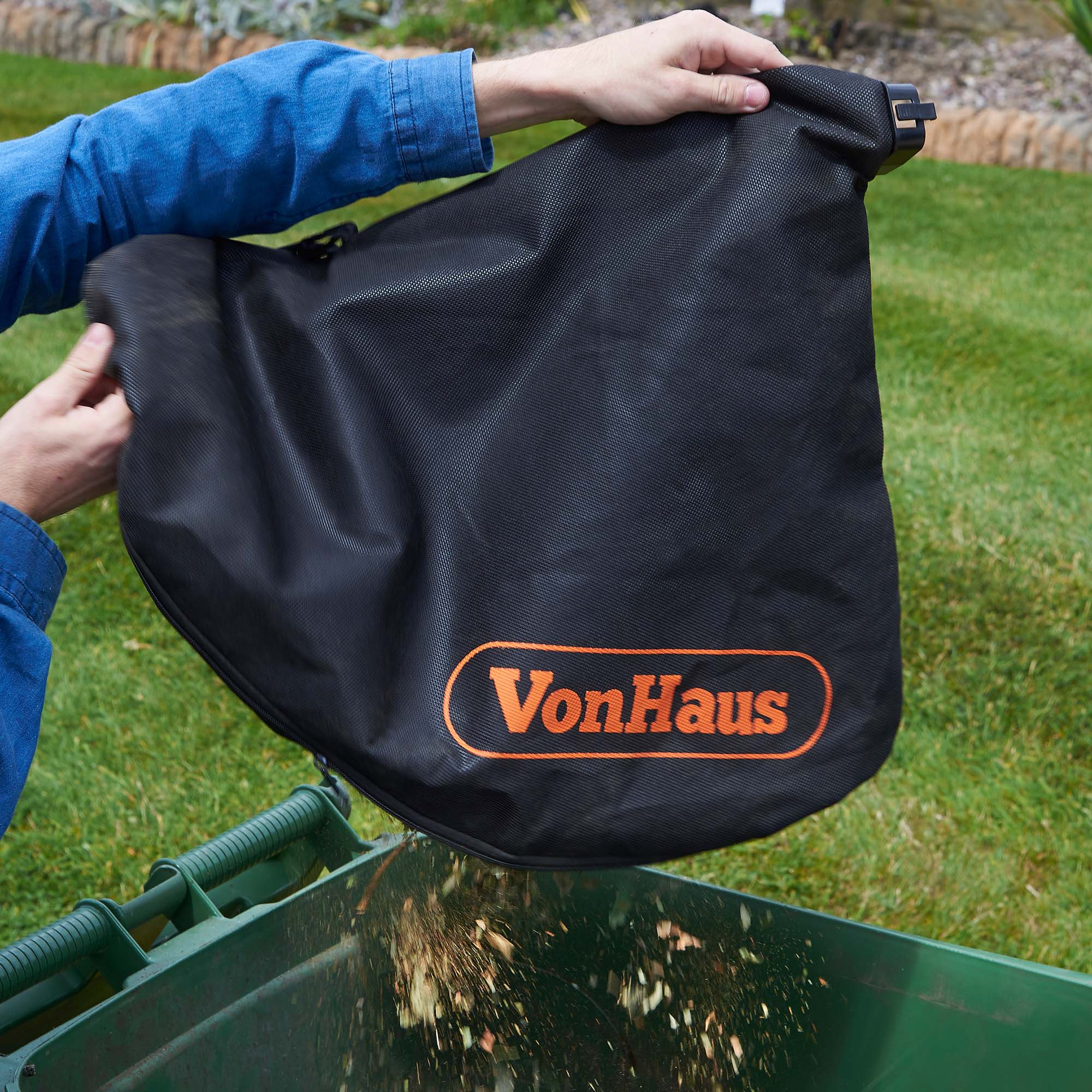 man emptying a vonhaus compost bag into a garden bin