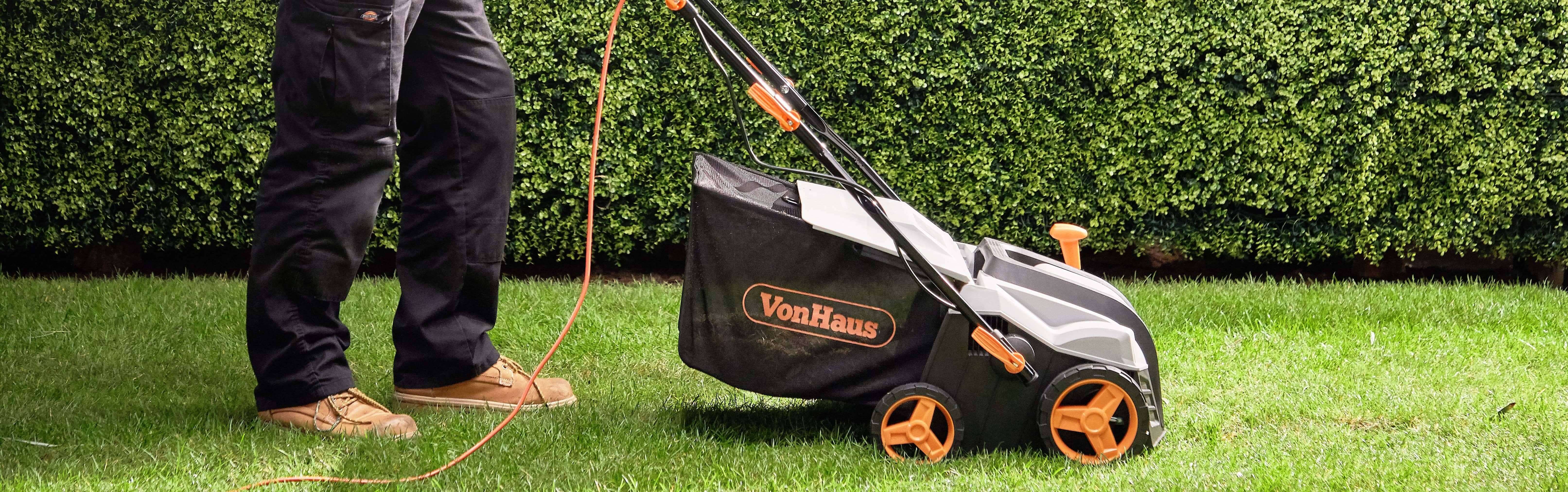 Man aerating a lawn with a scarifier